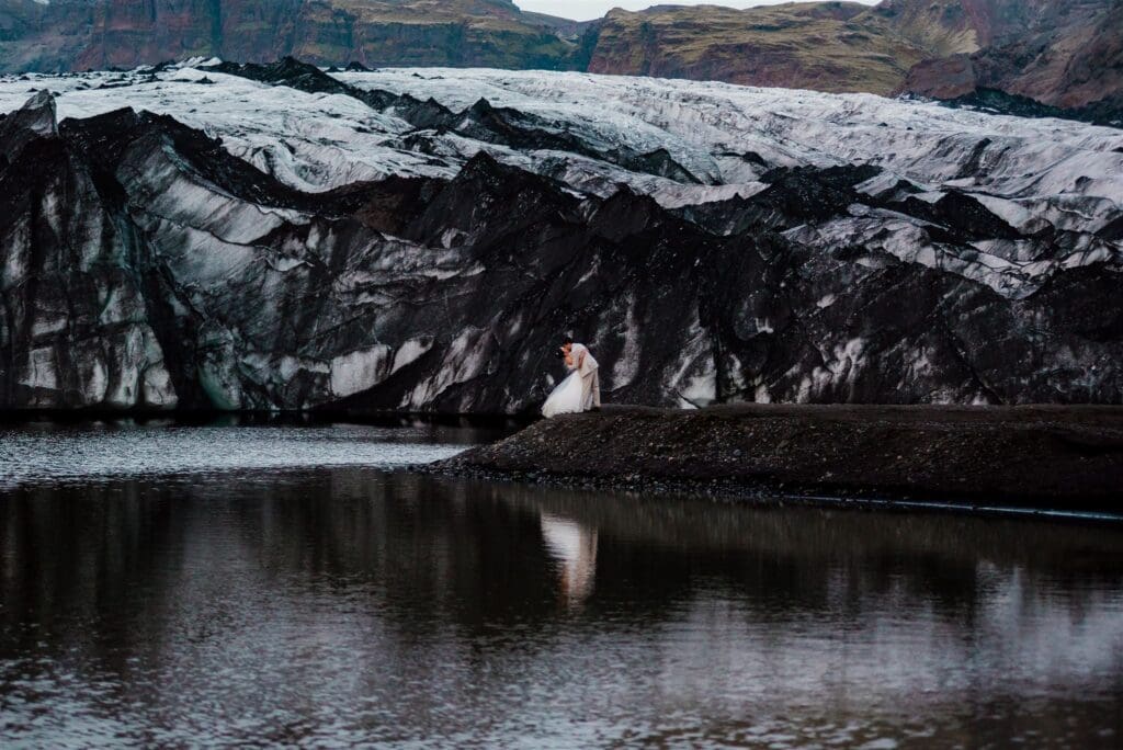 Couple sharing a quiet moment at Sólheimajökull Glacier in Iceland during a romantic elopement.