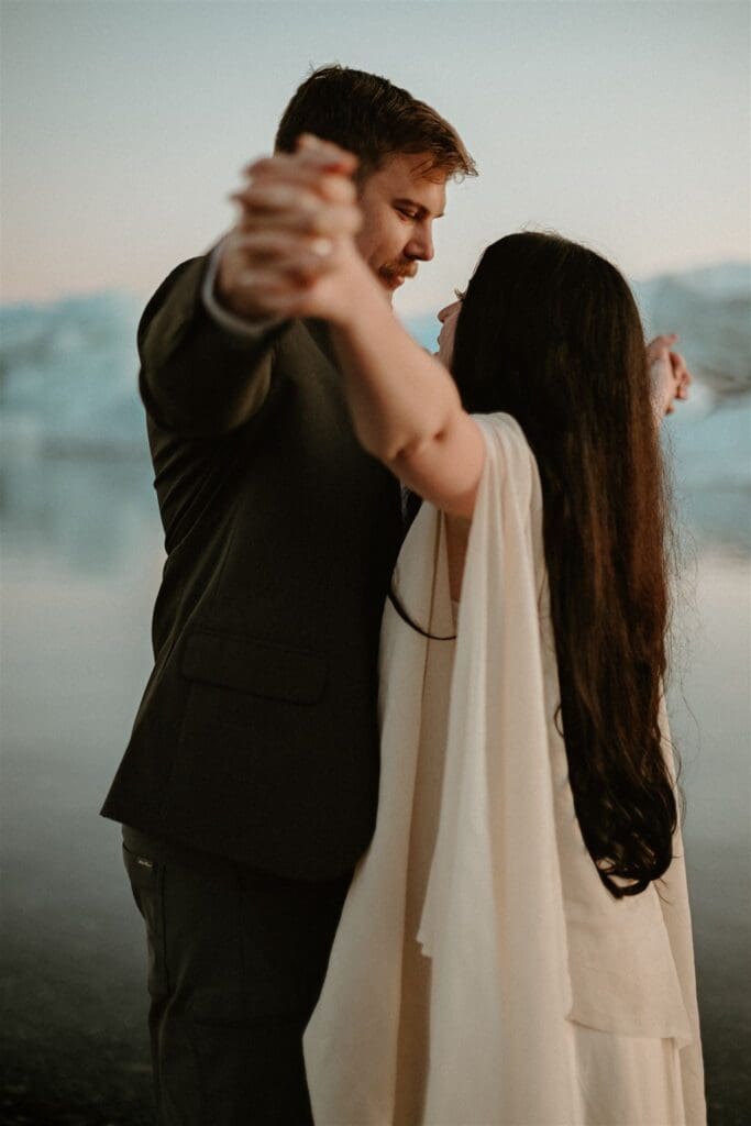 Couple slow dancing together during an intimate Iceland elopement, with soft light and a peaceful glacial backdrop.