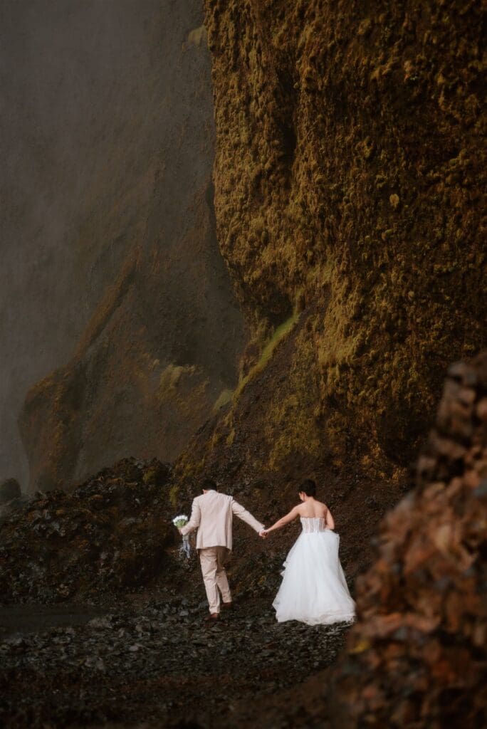 Couple standing together in front of Skógafoss waterfall on Iceland’s South Coast during an elopement.