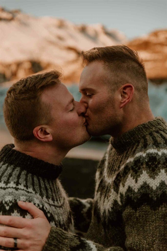 A male couple kisses after a proposal in Iceland